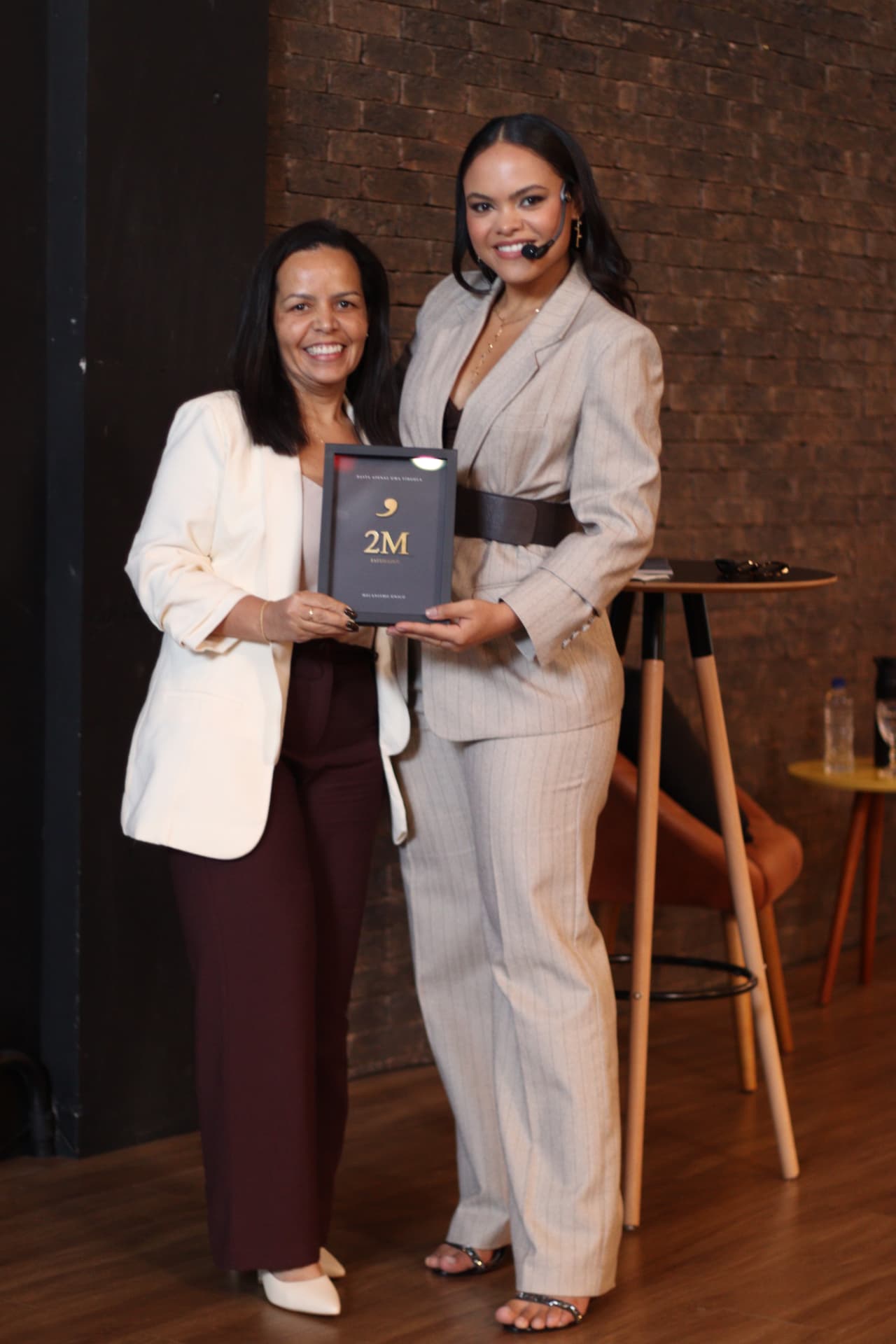 Delaine Nogueira recebendo a placa de R$ 2 milhões em vendas